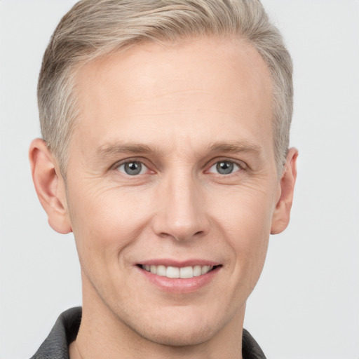 Joyful white adult male with short  brown hair and grey eyes