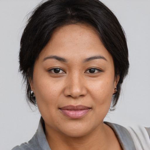 Joyful asian adult female with medium  brown hair and brown eyes