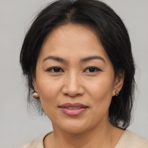 Joyful asian adult female with medium  brown hair and brown eyes