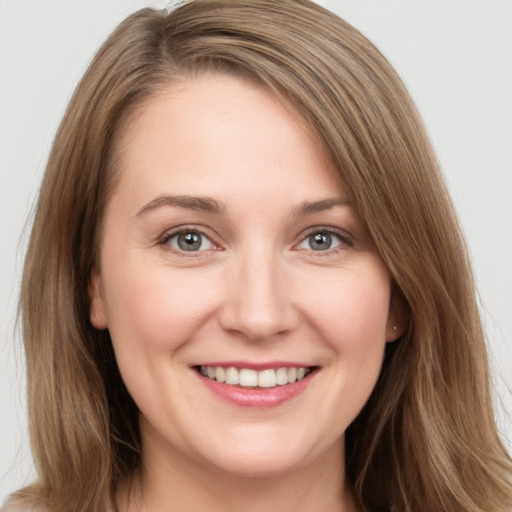 Joyful white young-adult female with long  brown hair and brown eyes