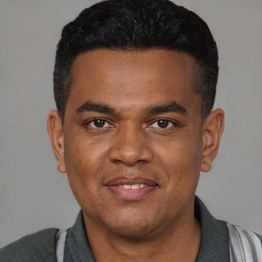 Joyful latino young-adult male with short  black hair and brown eyes