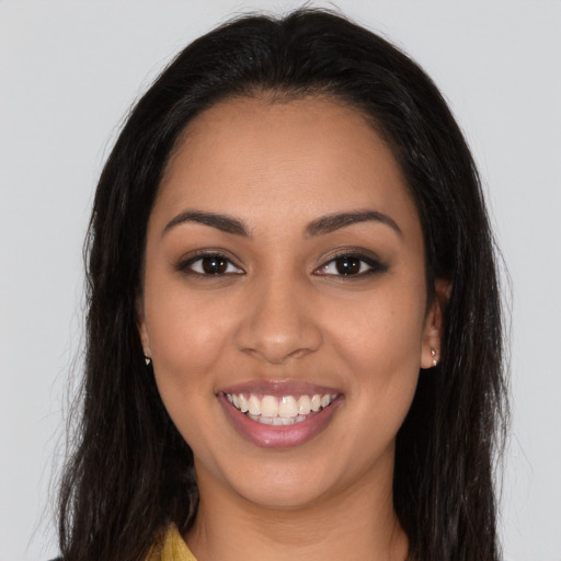 Joyful latino young-adult female with long  brown hair and brown eyes