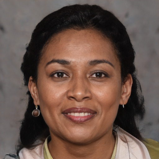 Joyful latino adult female with medium  black hair and brown eyes