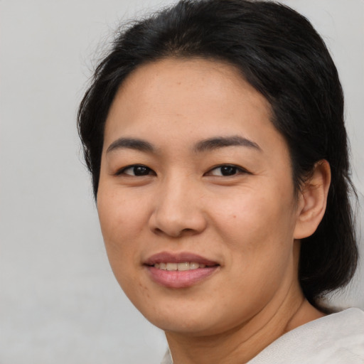 Joyful asian young-adult female with short  black hair and brown eyes