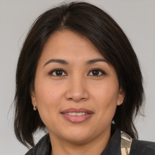 Joyful asian adult female with medium  brown hair and brown eyes