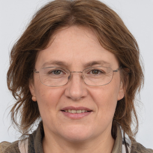 Joyful white adult female with long  brown hair and grey eyes