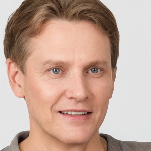 Joyful white adult male with short  brown hair and grey eyes