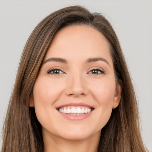 Joyful white young-adult female with long  brown hair and brown eyes