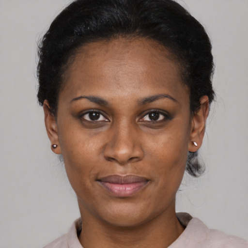 Joyful black young-adult female with short  black hair and brown eyes