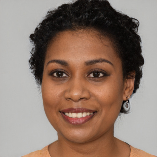 Joyful black young-adult female with short  brown hair and brown eyes