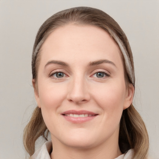 Joyful white young-adult female with medium  brown hair and grey eyes