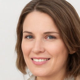 Joyful white adult female with medium  brown hair and green eyes