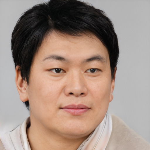 Joyful asian young-adult male with short  brown hair and brown eyes