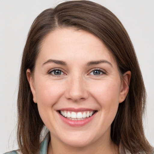 Joyful white young-adult female with medium  brown hair and grey eyes