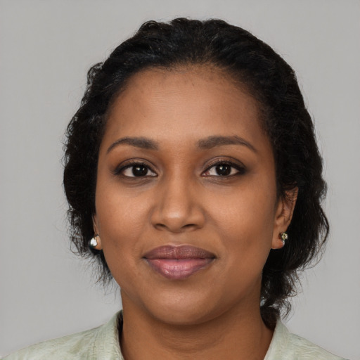 Joyful black young-adult female with medium  black hair and brown eyes