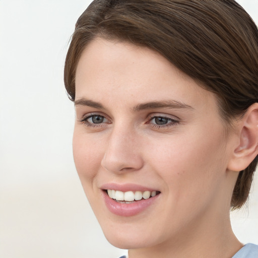 Joyful white young-adult female with short  brown hair and grey eyes