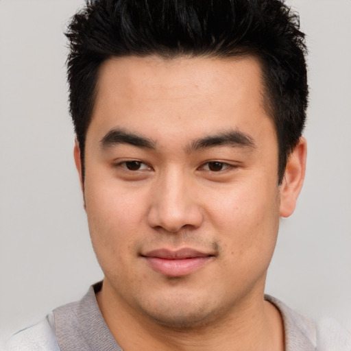 Joyful asian young-adult male with short  black hair and brown eyes