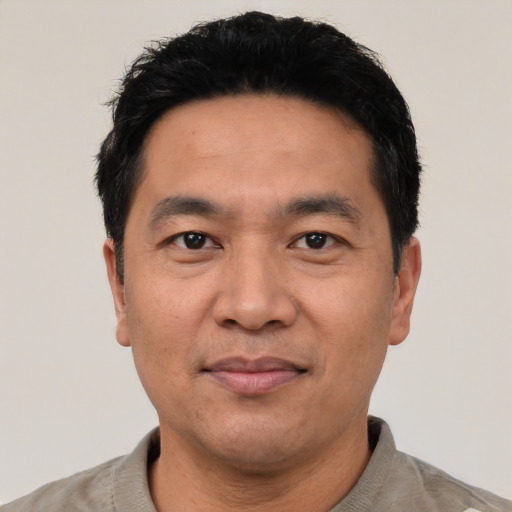 Joyful asian adult male with short  black hair and brown eyes