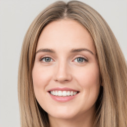 Joyful white young-adult female with long  brown hair and green eyes