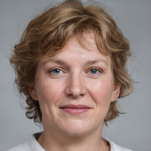 Joyful white adult female with medium  brown hair and blue eyes