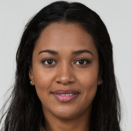 Joyful black young-adult female with long  brown hair and brown eyes