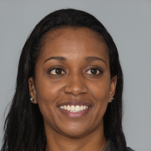 Joyful black young-adult female with long  black hair and brown eyes