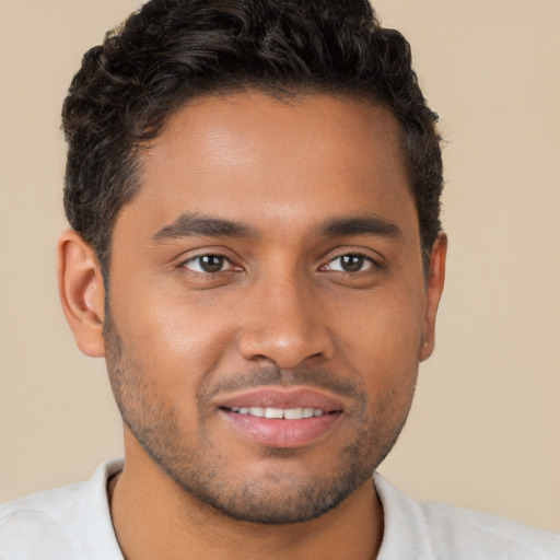 Joyful black young-adult male with short  brown hair and brown eyes