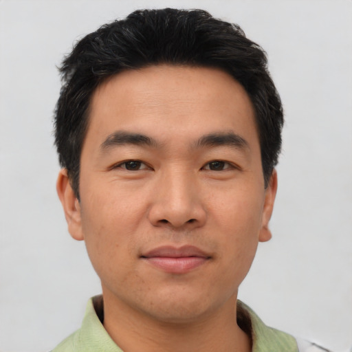 Joyful asian young-adult male with short  black hair and brown eyes