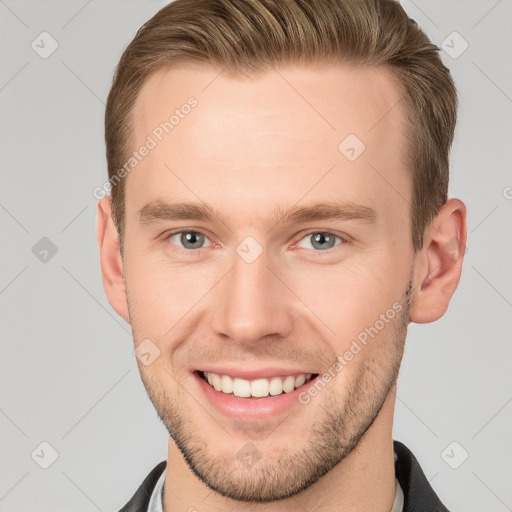 Joyful white young-adult male with short  brown hair and grey eyes