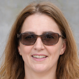 Joyful white adult female with medium  brown hair and blue eyes