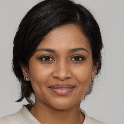 Joyful black young-adult female with medium  brown hair and brown eyes