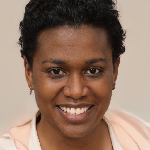 Joyful black young-adult female with short  brown hair and brown eyes