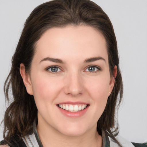 Joyful white young-adult female with medium  brown hair and grey eyes