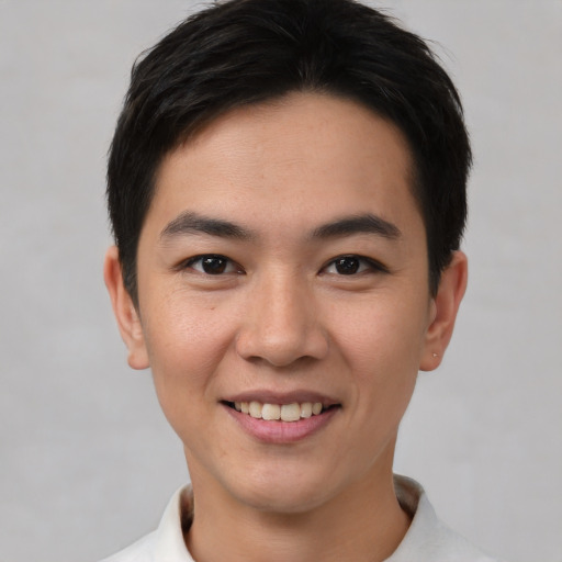 Joyful asian young-adult male with short  brown hair and brown eyes