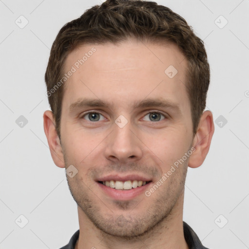 Joyful white young-adult male with short  brown hair and grey eyes