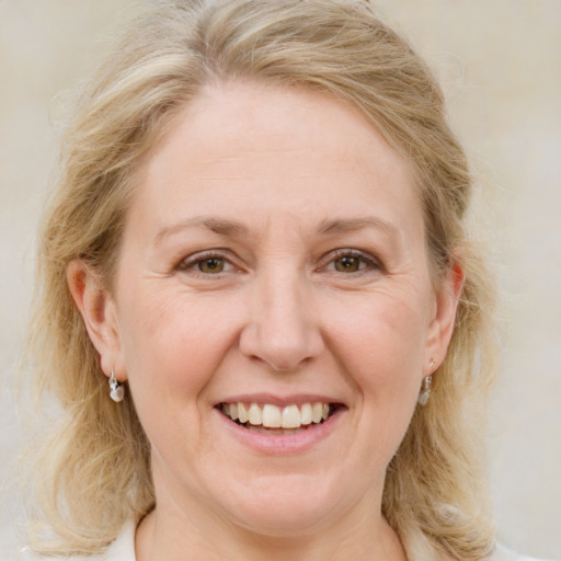 Joyful white adult female with medium  brown hair and blue eyes