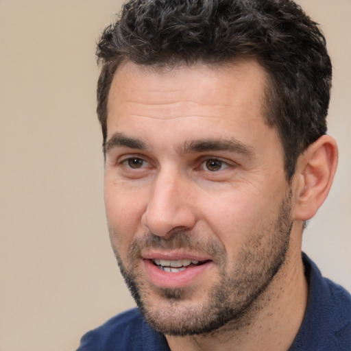 Joyful white adult male with short  black hair and brown eyes