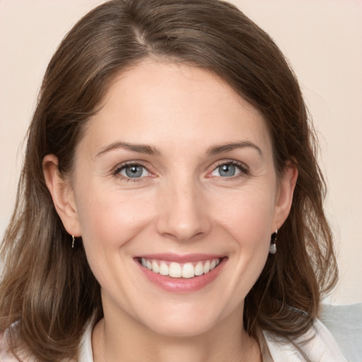 Joyful white young-adult female with medium  brown hair and grey eyes