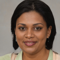 Joyful black adult female with medium  brown hair and brown eyes