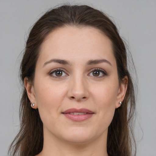 Joyful white young-adult female with long  brown hair and brown eyes