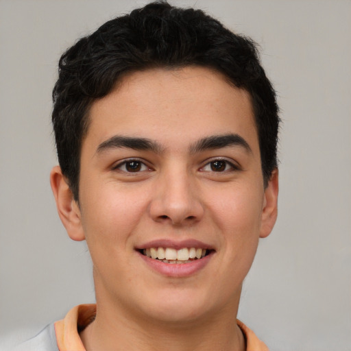 Joyful latino young-adult male with short  brown hair and brown eyes