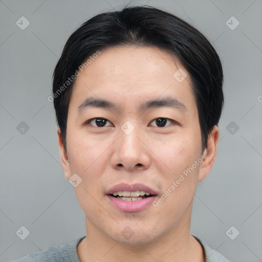 Joyful asian young-adult male with short  black hair and brown eyes