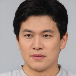Joyful asian young-adult male with short  black hair and brown eyes