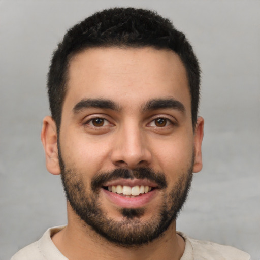 Joyful latino young-adult male with short  black hair and brown eyes