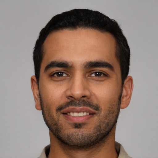 Joyful latino young-adult male with short  black hair and brown eyes