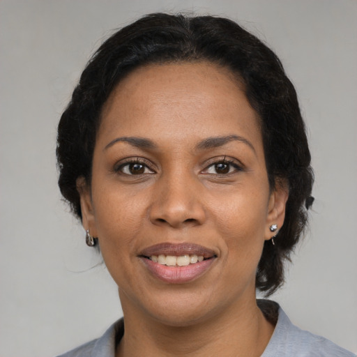 Joyful black adult female with medium  black hair and brown eyes