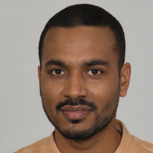 Joyful black young-adult male with short  black hair and brown eyes