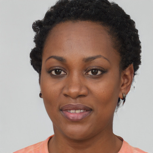 Joyful black young-adult female with short  black hair and brown eyes