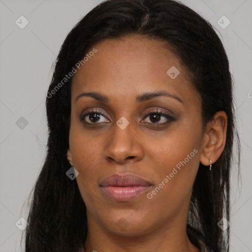 Joyful black young-adult female with long  brown hair and brown eyes