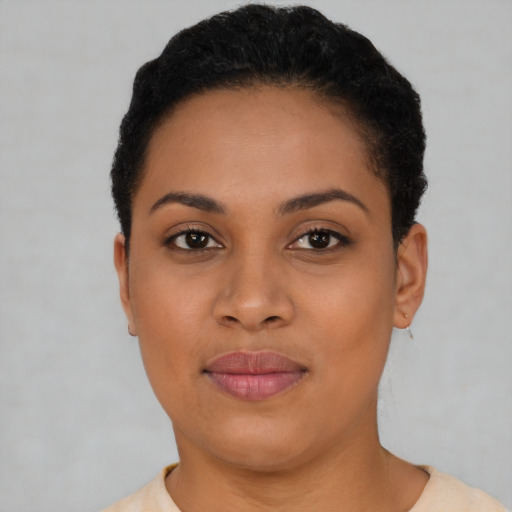 Joyful black young-adult female with short  black hair and brown eyes